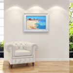 Beach oil painting on canvas with rich impasto texture hanging in a modern living room with a white sofa, showing full room decor.