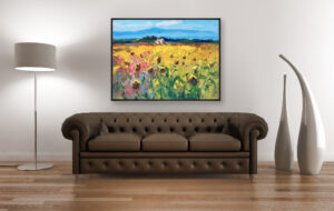 Landscape oil painting on canvas with rich impasto texture hanging in a modern living room with a brown sofa, showing full room decor.